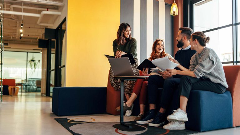 Workers smiling as they collaborate in the office
